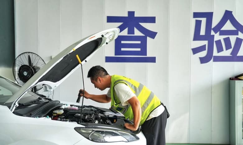 Technician checking a vehicle in an inspection bay